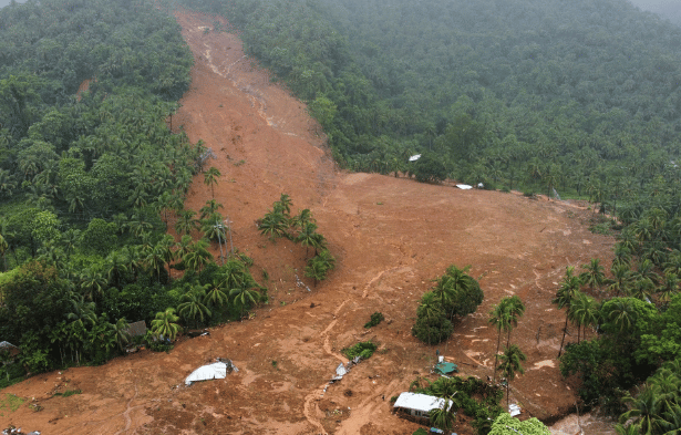 Aerial view of the 2024 Wayanad landslide showing displaced earth and damaged homes on a hillside